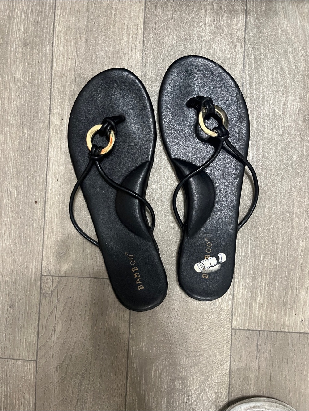 BAMBOO Black Toe-Loop Sandals with Gold Ring Accent